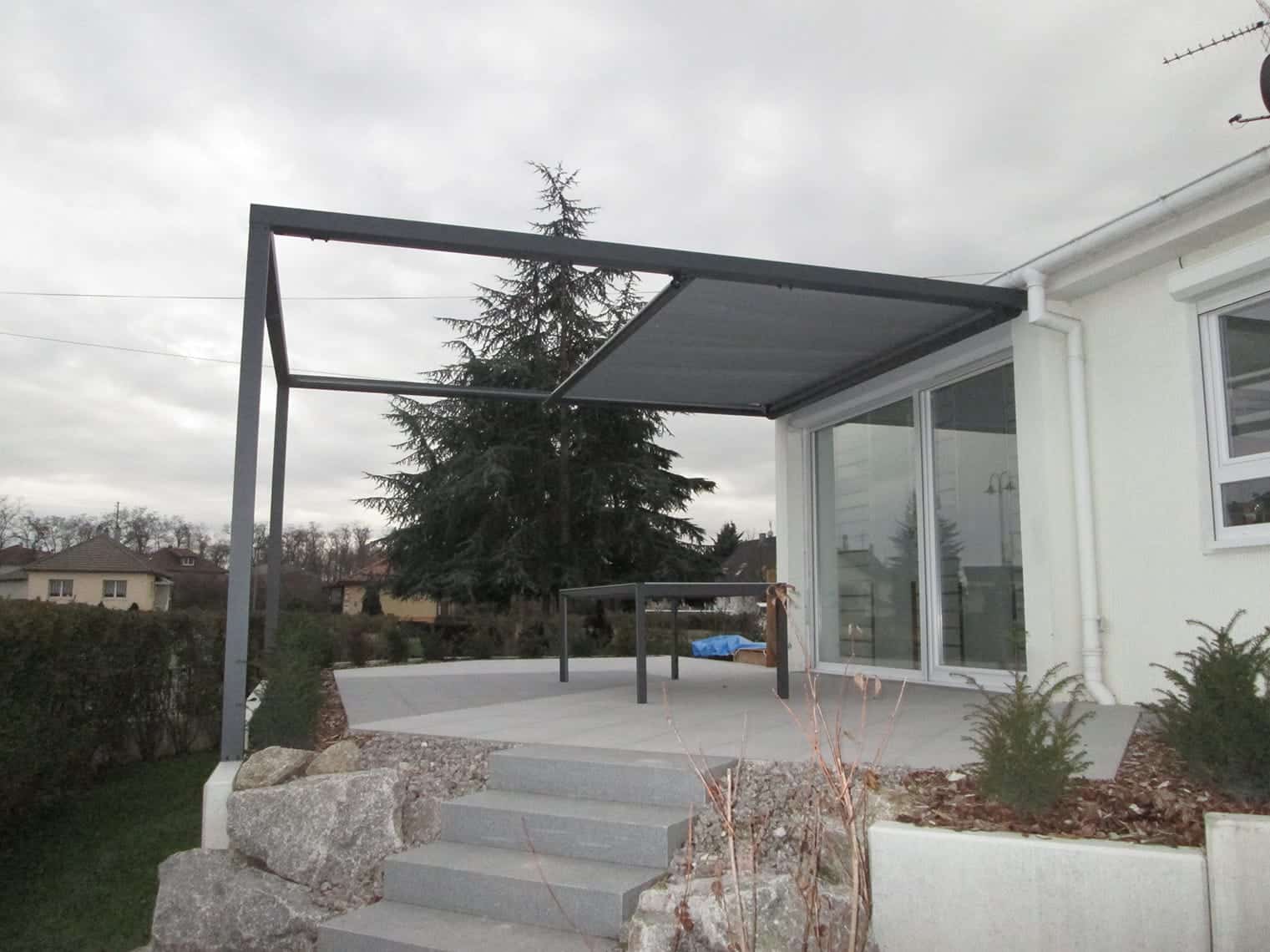 Exemple de réalisation par Verral d'une pergola Tensionata grise à moitié ouverte, réalisé par Verral