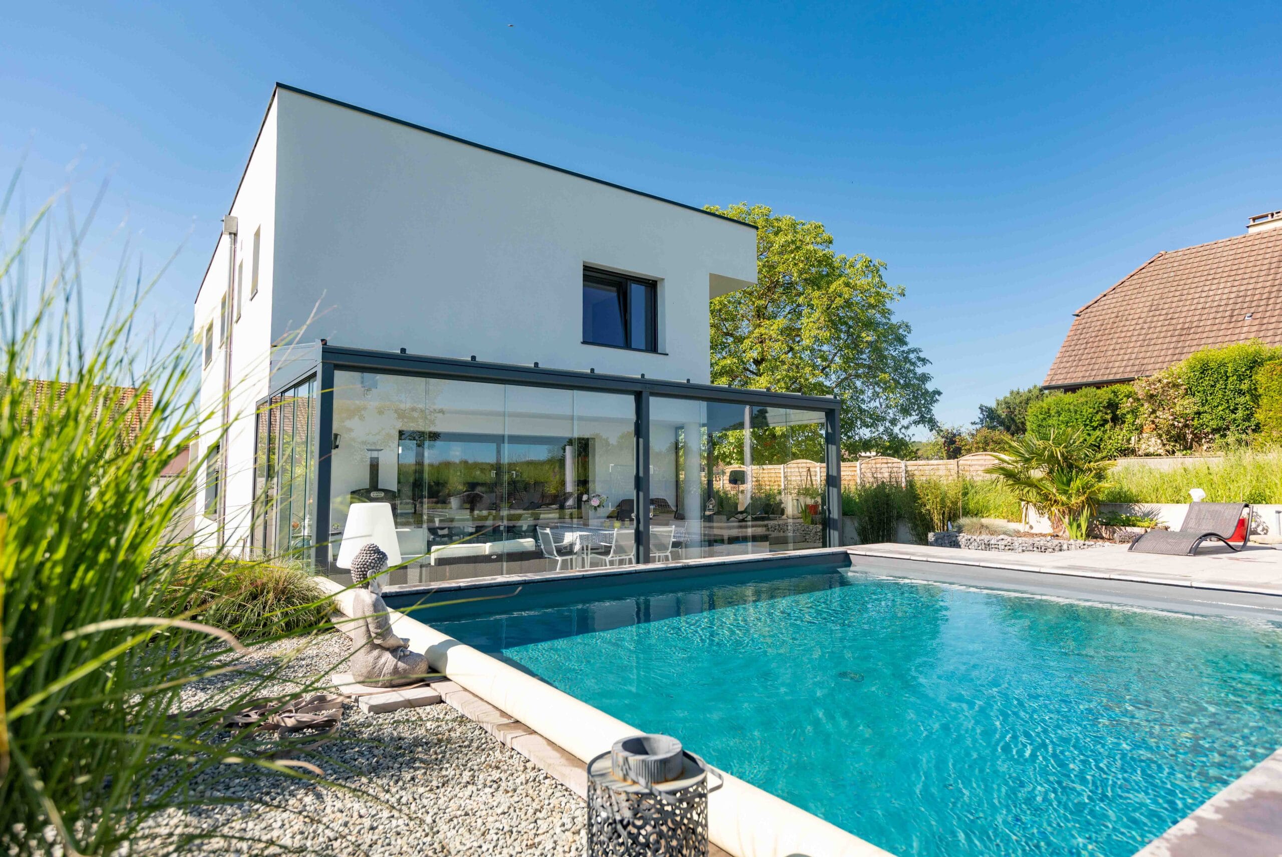 Exemple de réalisation par Verral d'une pergola à toit vitré réalisée par Verral donnant directement une piscine